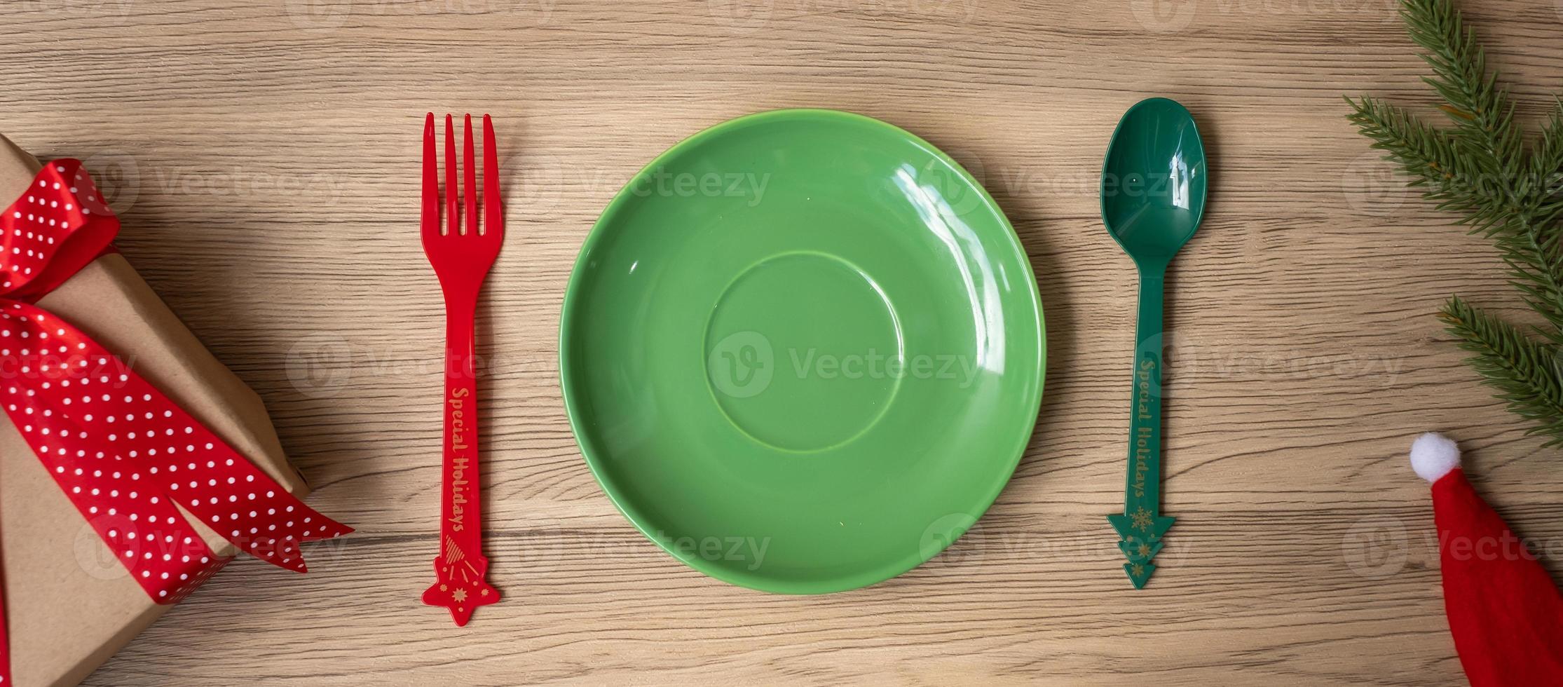 Merry Christmas with plate, fork and spoon on wood table background. Xmas, party and happy New Year concept photo