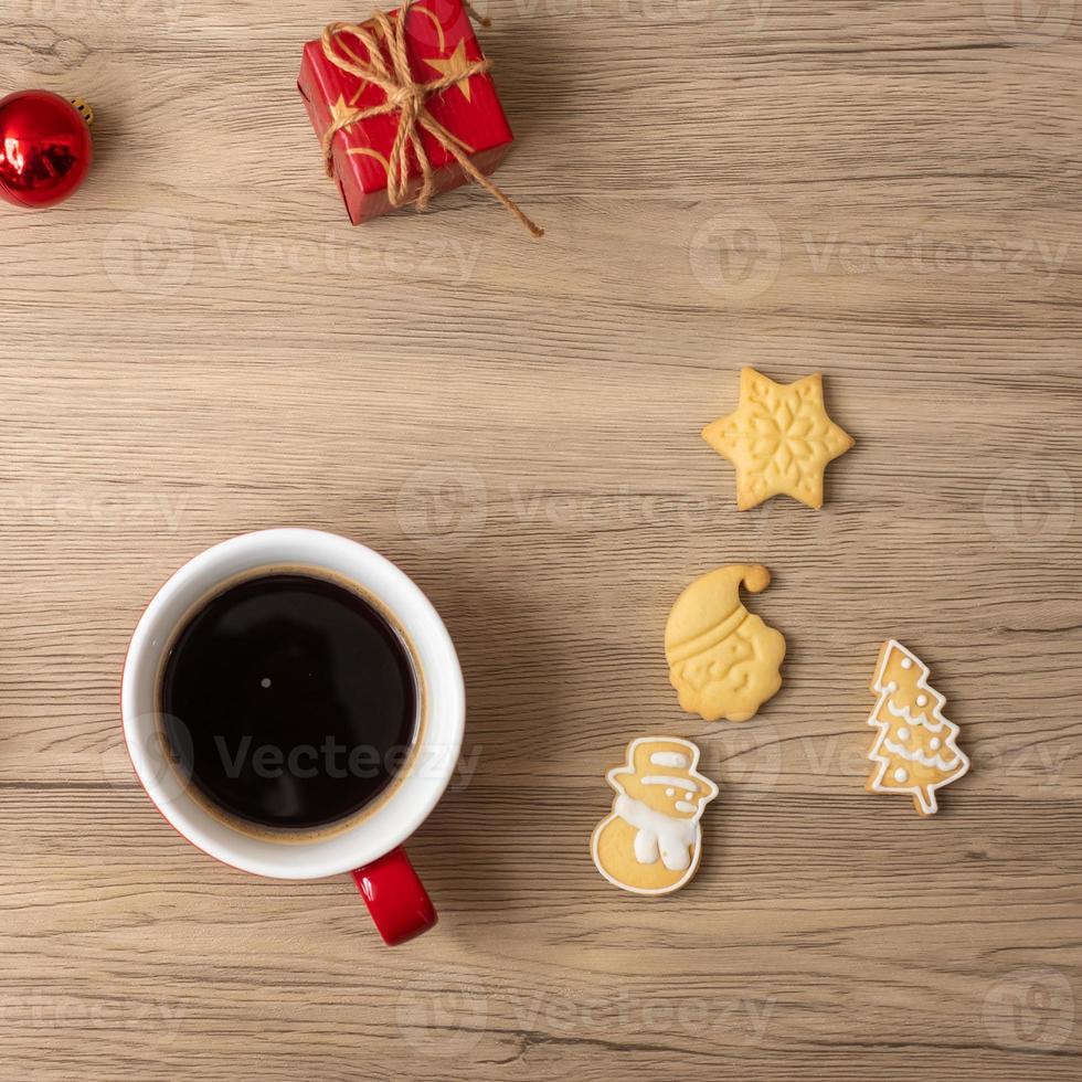 feliz navidad con galletas caseras y taza de café sobre fondo de mesa de madera. concepto de víspera de navidad, fiesta, vacaciones y feliz año nuevo foto