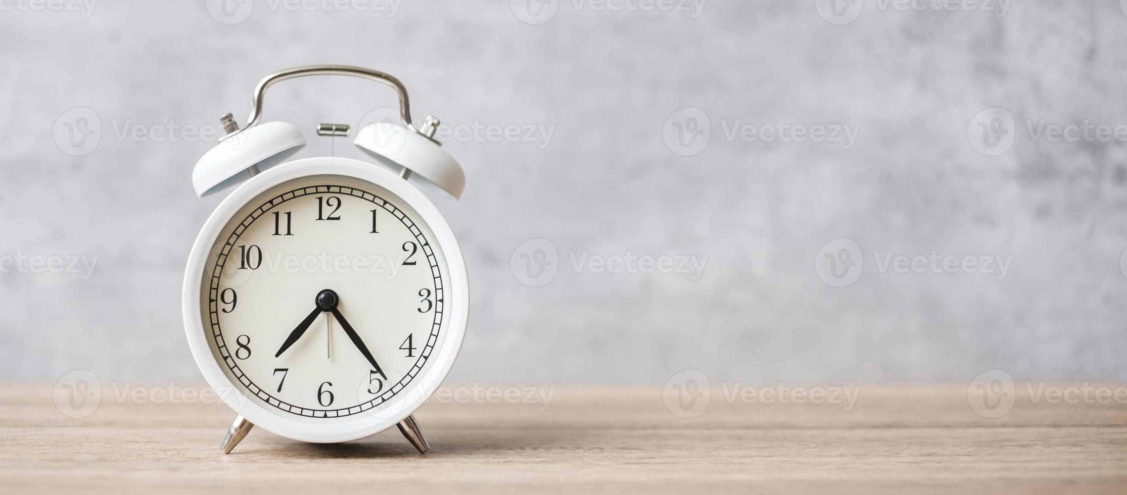 Vintage alarm clock on wooden table background and copy space for text. Activity, daily routine, morning, countdown, workout and Work life balance concept photo