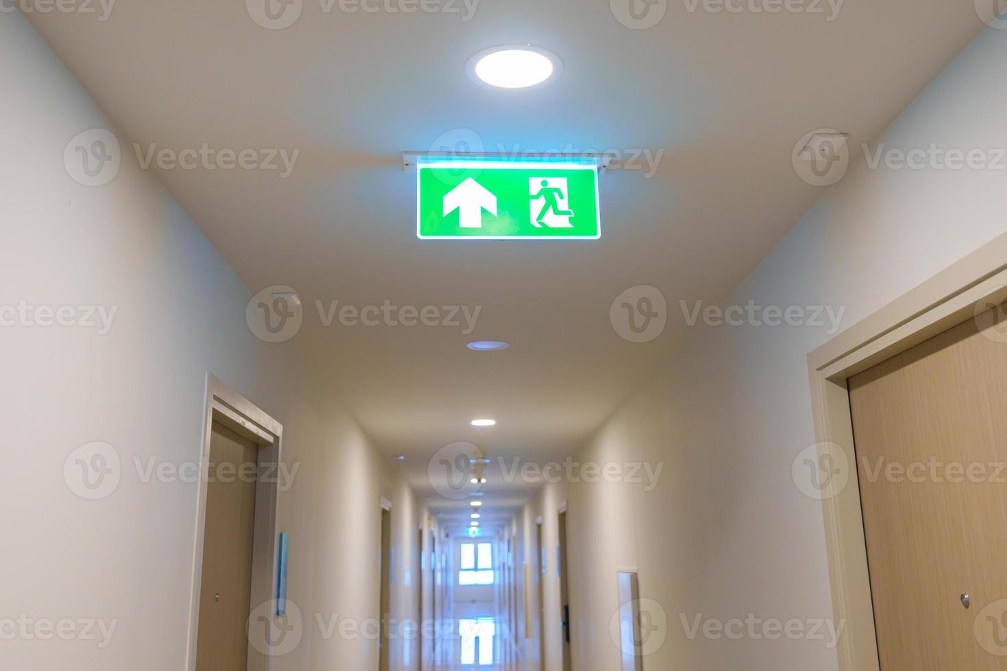 Fire Emergency exit sign on the wall background inside building. Safety concept photo