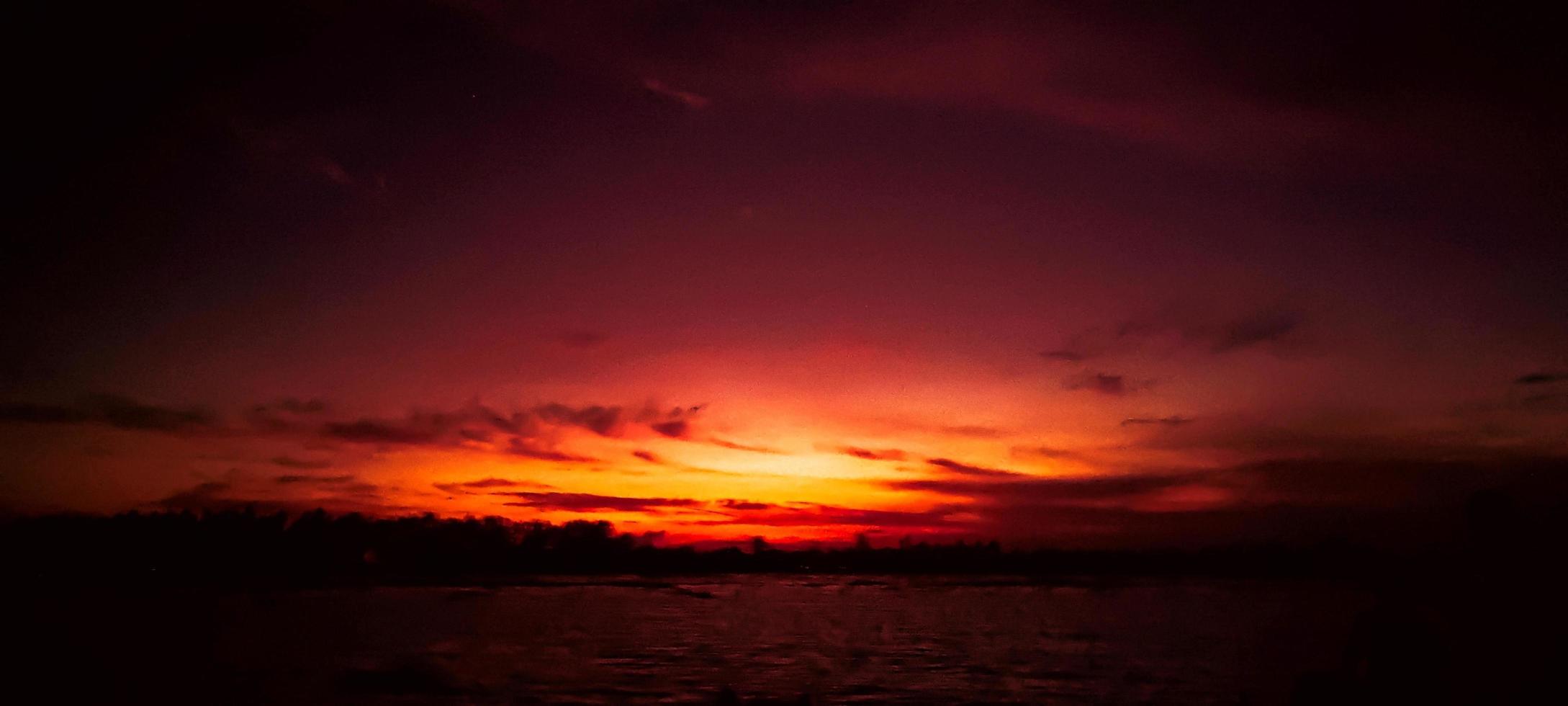 Red color sky clear view background with cloud behind the Sun photo