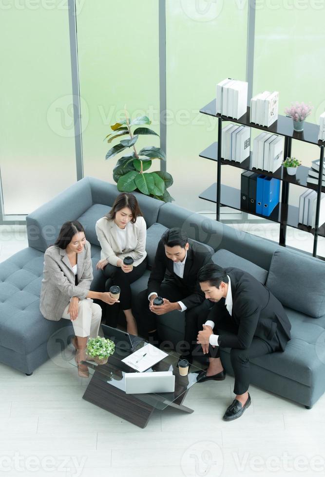 Young entrepreneurs in Asia Take a break to relax in the relaxation room after a meeting. By watching movies, taking photos, talking photo
