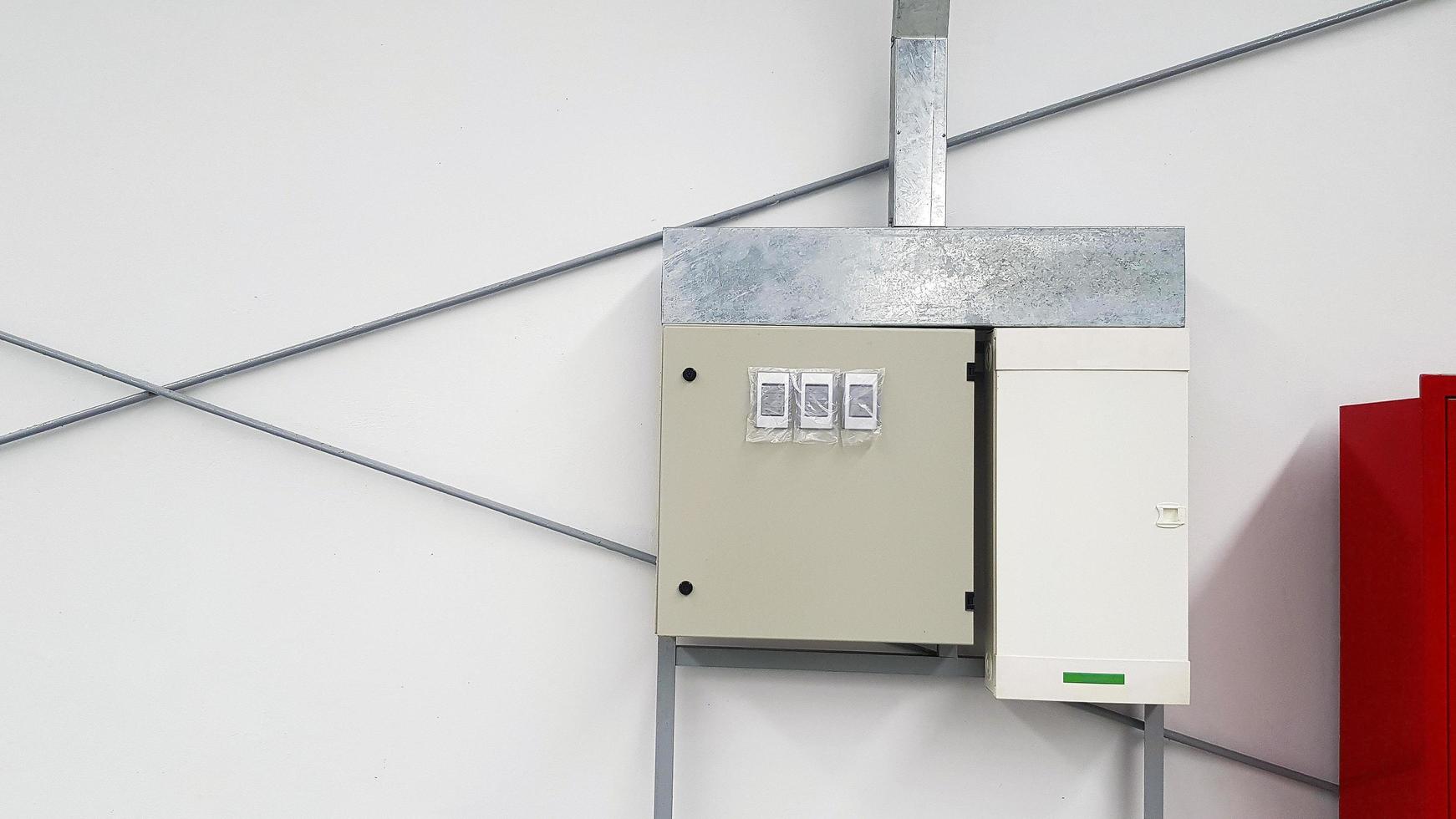Electrical breaker stainless steel box with control box install on white concrete wall with copy space in industrial. Electric and lighting system photo