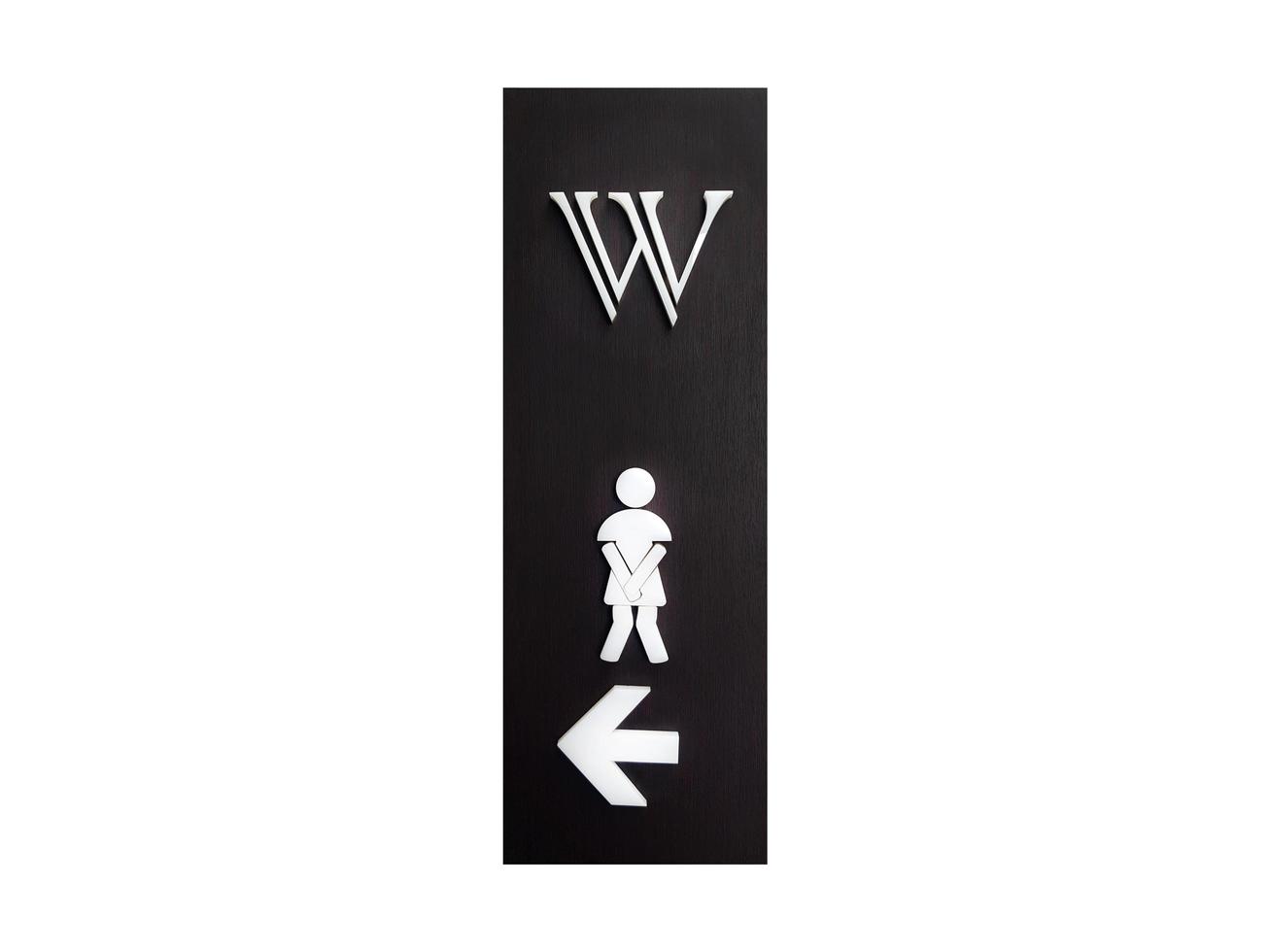 Black wooden of woman's public toilet sign with direction telling people to turn left to go restroom or washroom isolated on white background. The symbol or icon give people and women information. photo