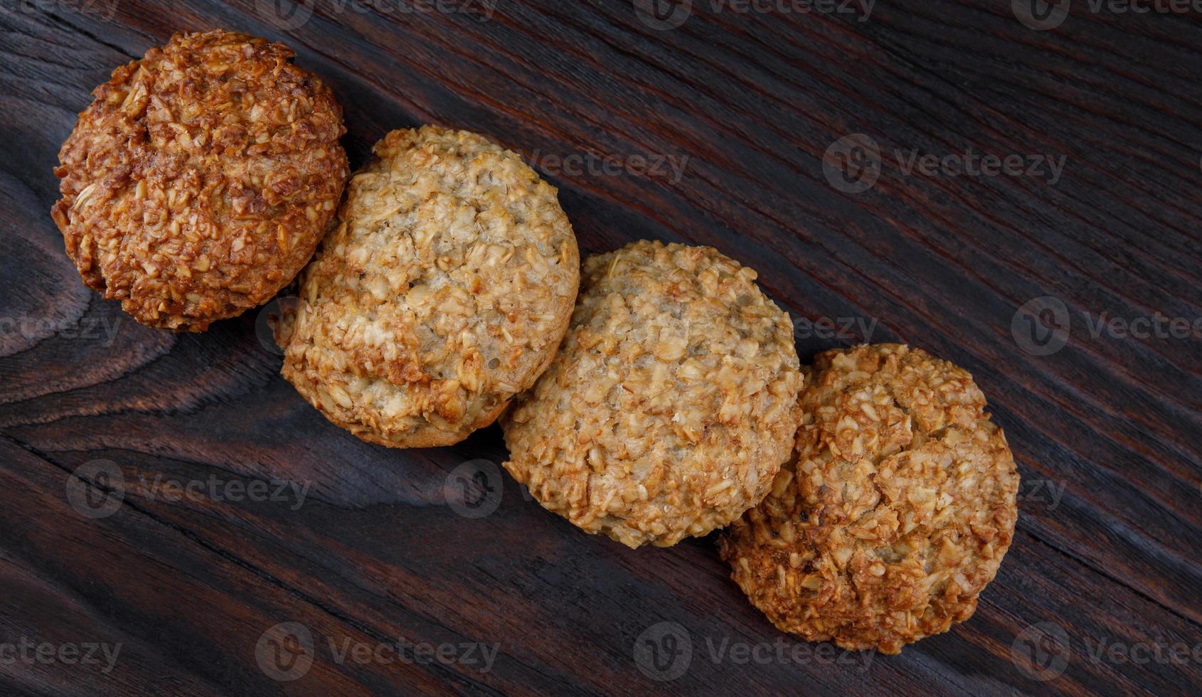 Oatmeal cookies laid out in a row on a wooden board top view. Rustic oatmeal cookies. photo