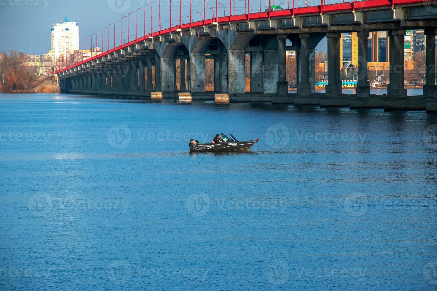Fishermen on a boat on the river catch fish in autumn. Fishing is a special kind of sport. photo