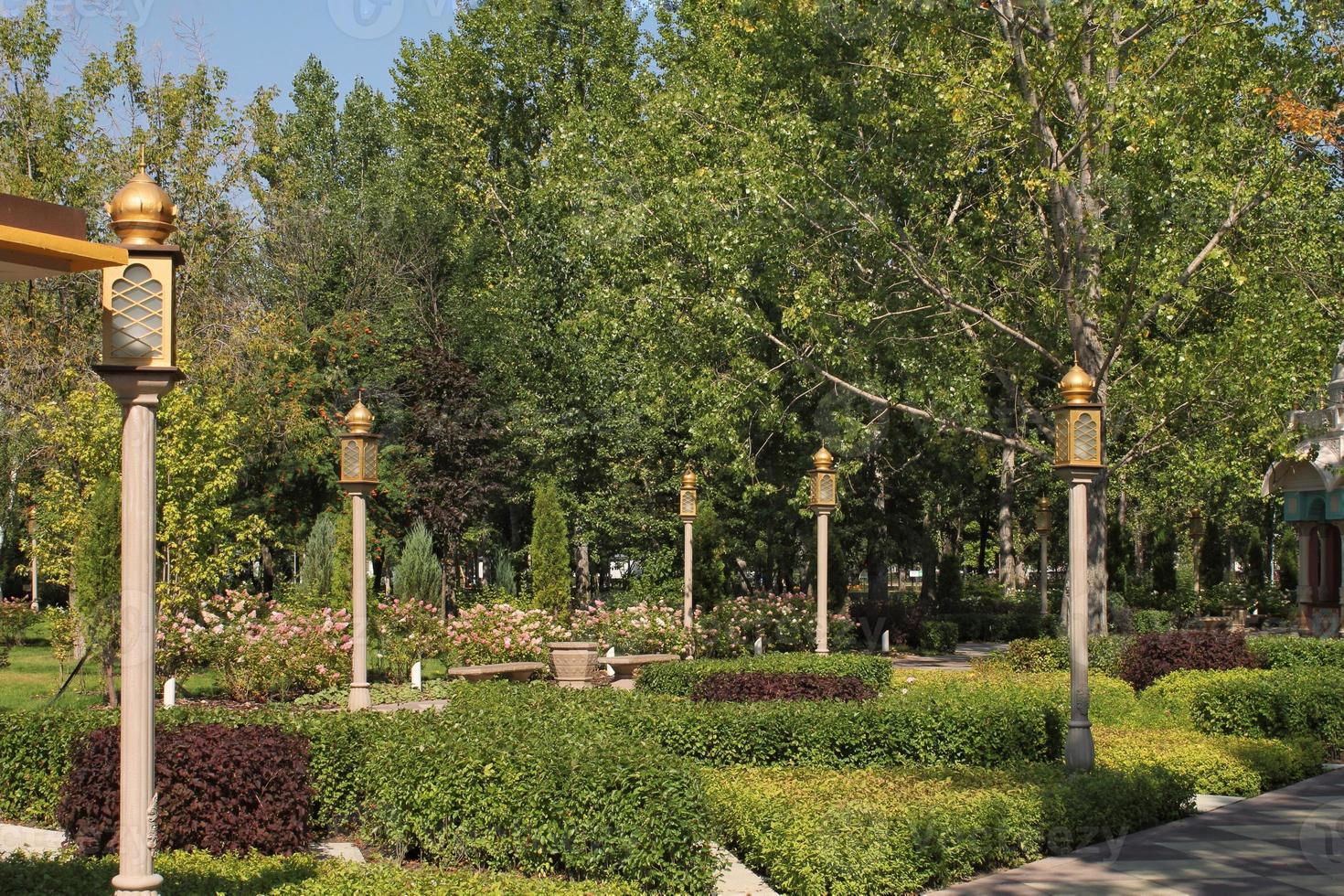 árboles y flores en el parque de la ciudad con linterna de estilo indio. Zona peatonal para caminar. planificación urbana, concepto de espacio público. zona de recreo del pueblo. arquitectura diseño cómodo jardín. sendero foto