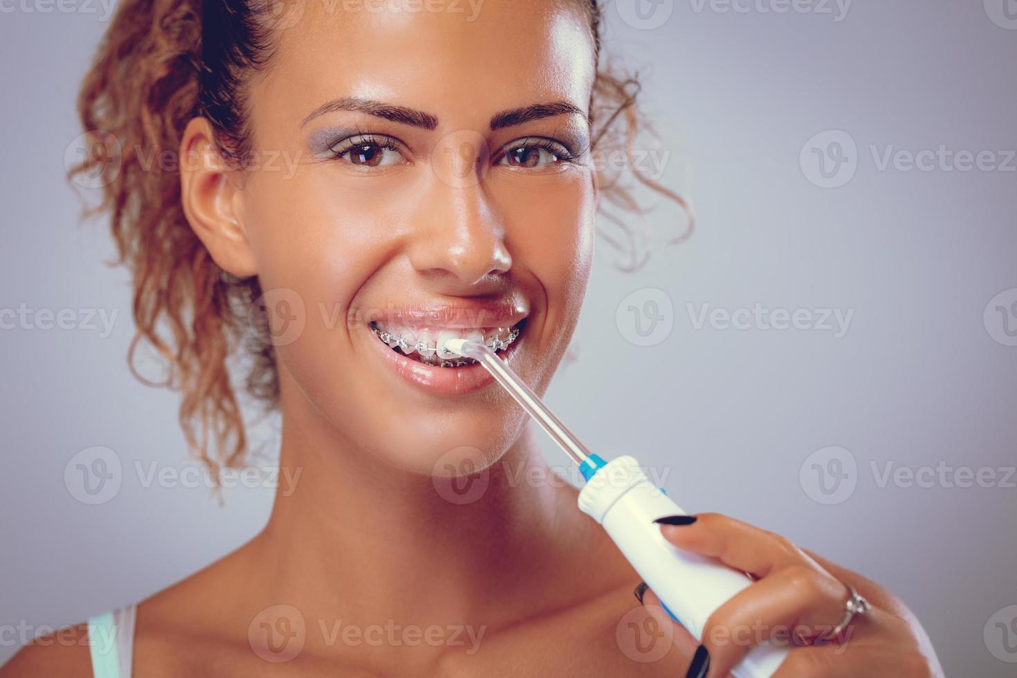 cepillarse los dientes con irrigador dental foto