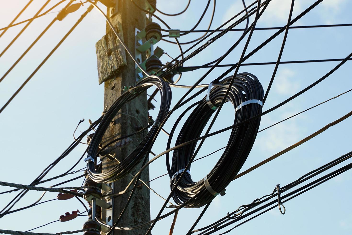 alambre y cable de internet envueltos en una bobina en un poste de luz que se ven desordenados, desordenados, poco atractivos. enfoque suave y selectivo. foto