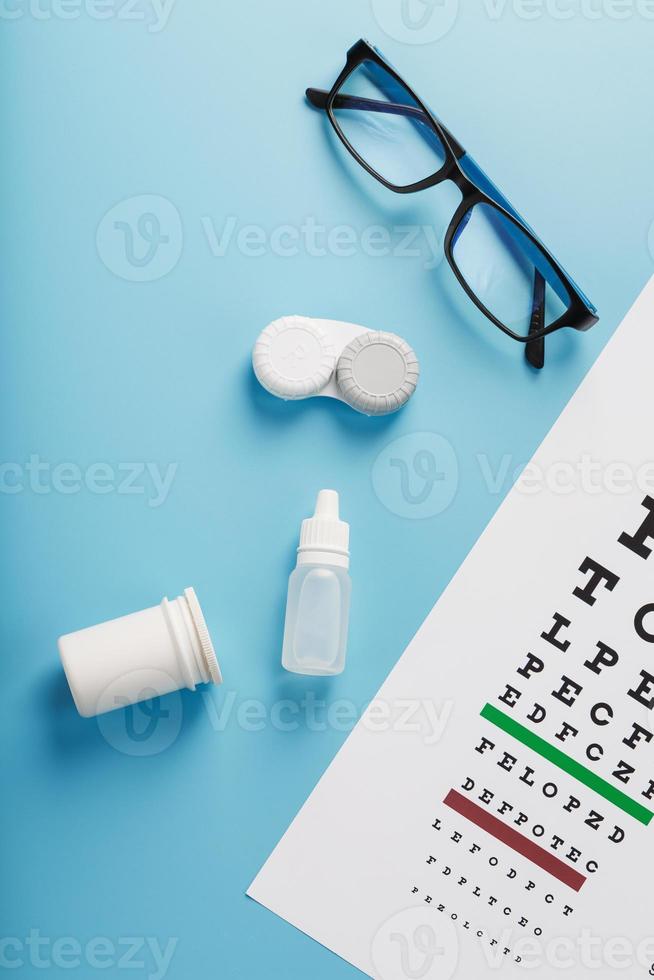 Vision checks and prevention, glasses, lenses and drops for vision correction on a blue background photo