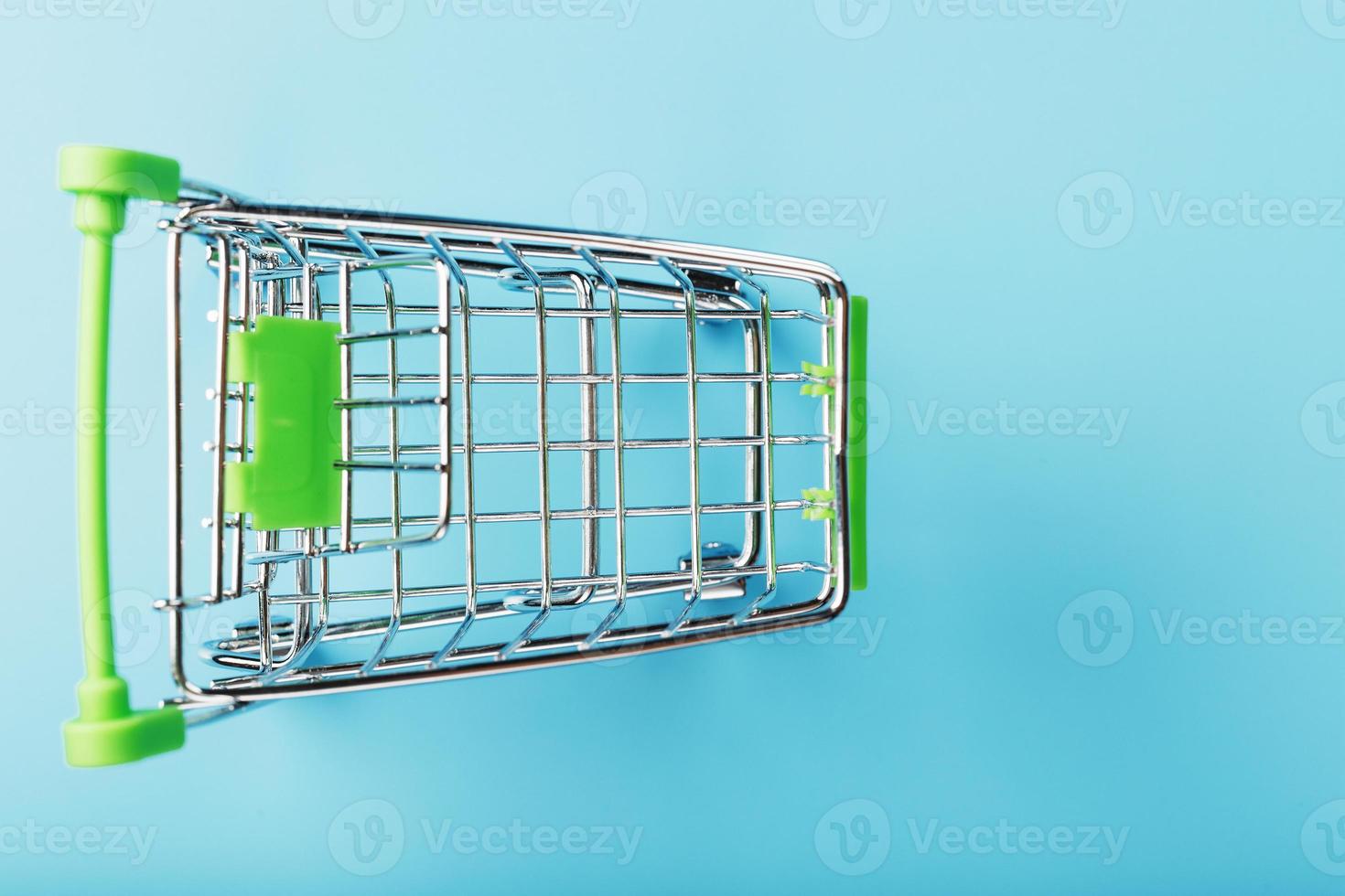 Supermarket shopping cart isolated on blue background. photo