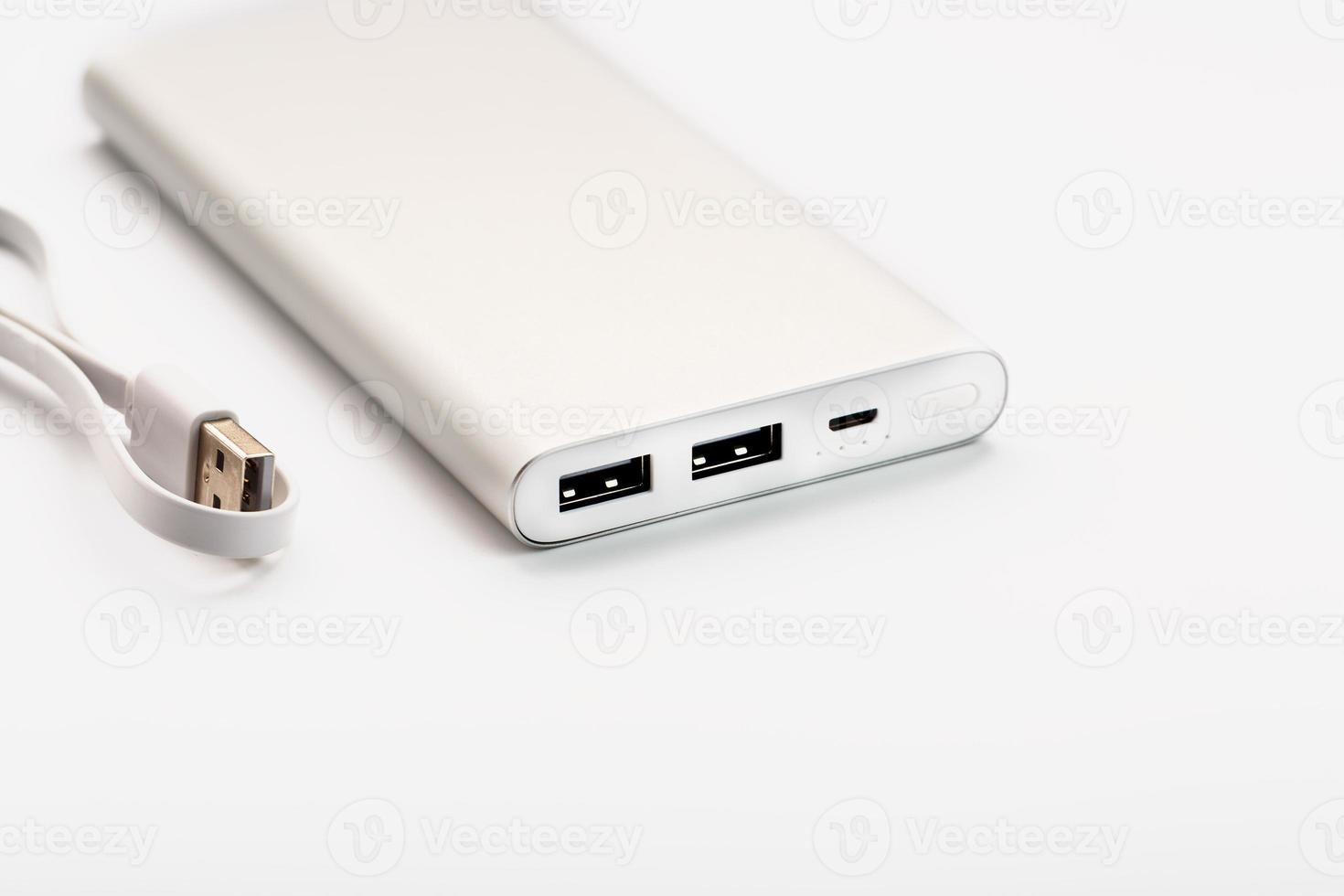 Powerbank for charging mobile devices with cable, on a white background. photo