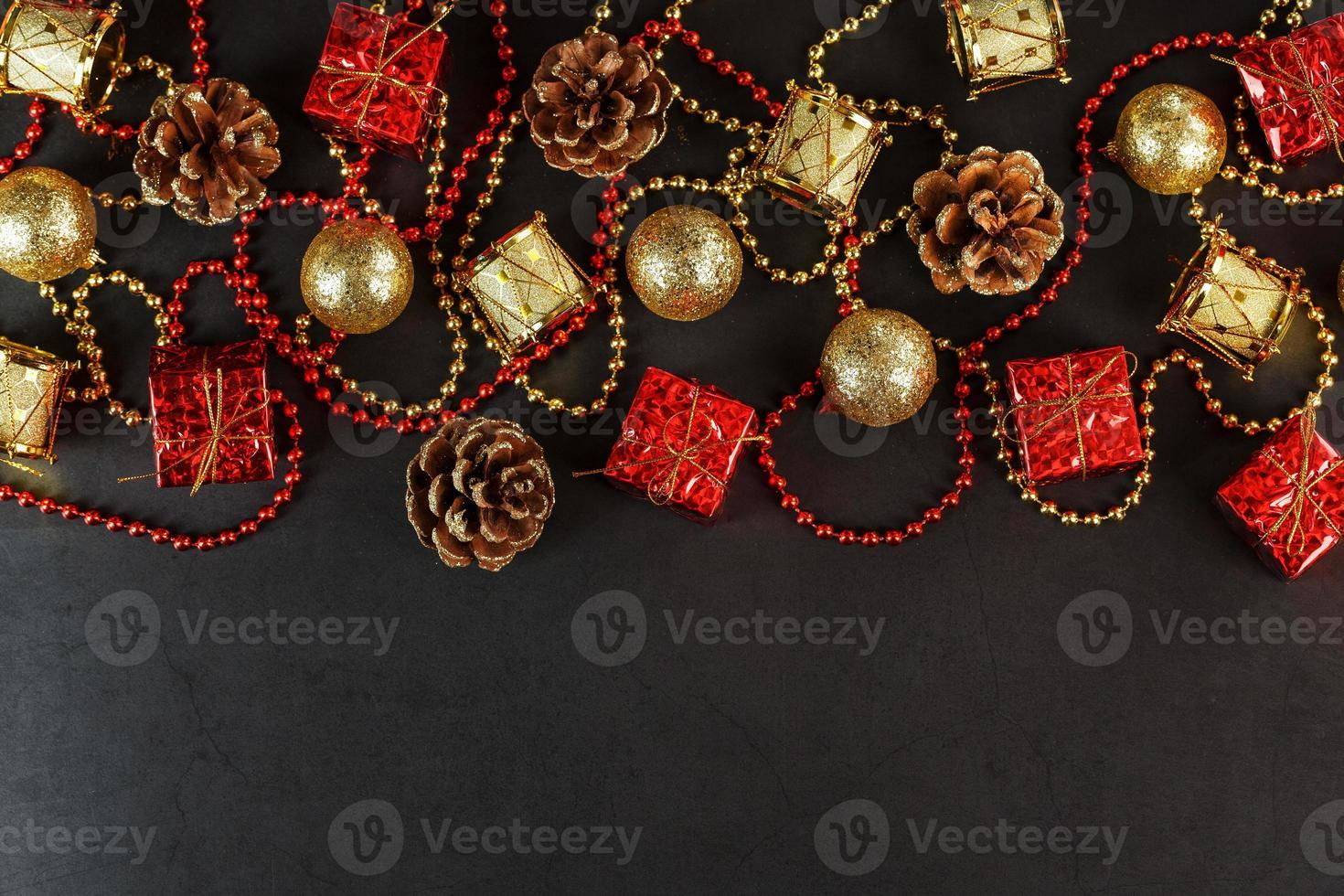 Christmas decorations in gold and red on a black background with free space. photo