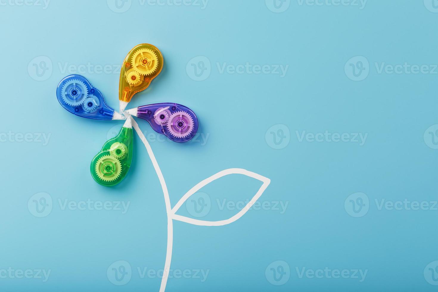Stationery correction tapes in the shape of a flower of different colors on a blue background. photo