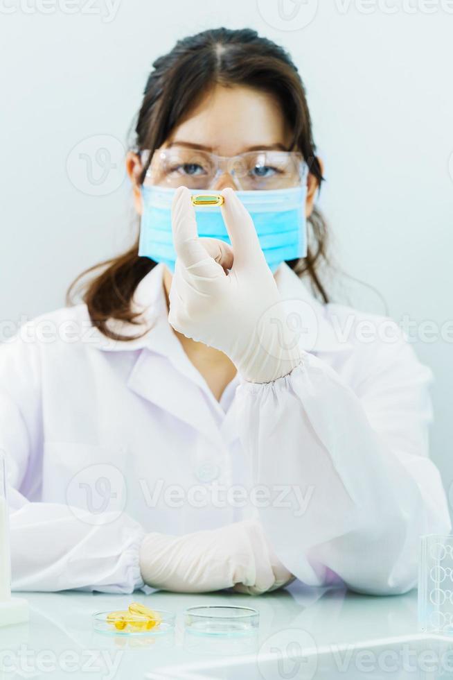 Scientist holding Omega 3 capsule in labcoat photo
