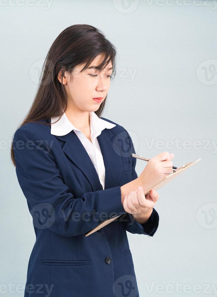 Asian woman long hair and wearing suit  with clipboard and pen in hands photo