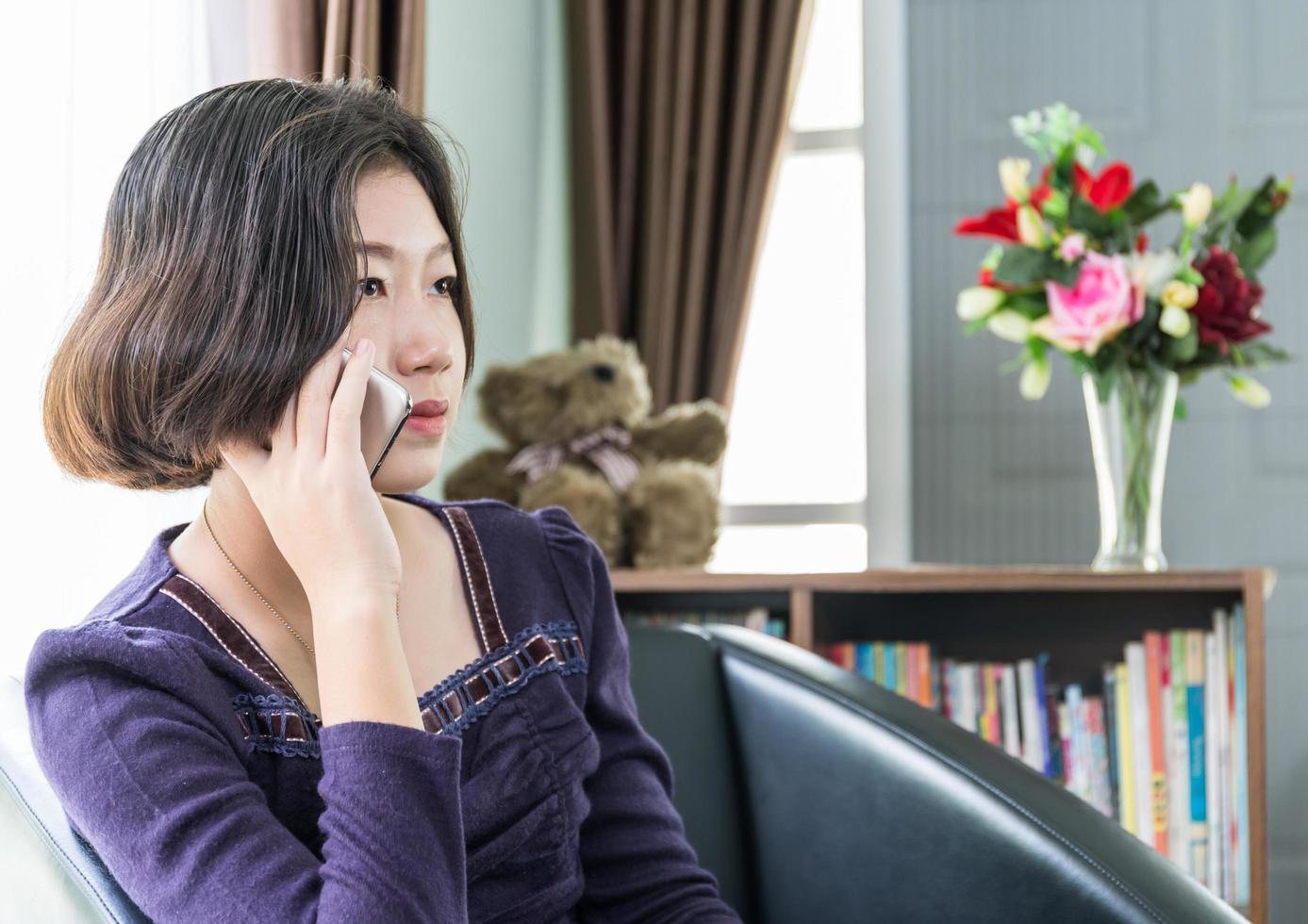 Young asian woman short hair use mobile phone in living room photo