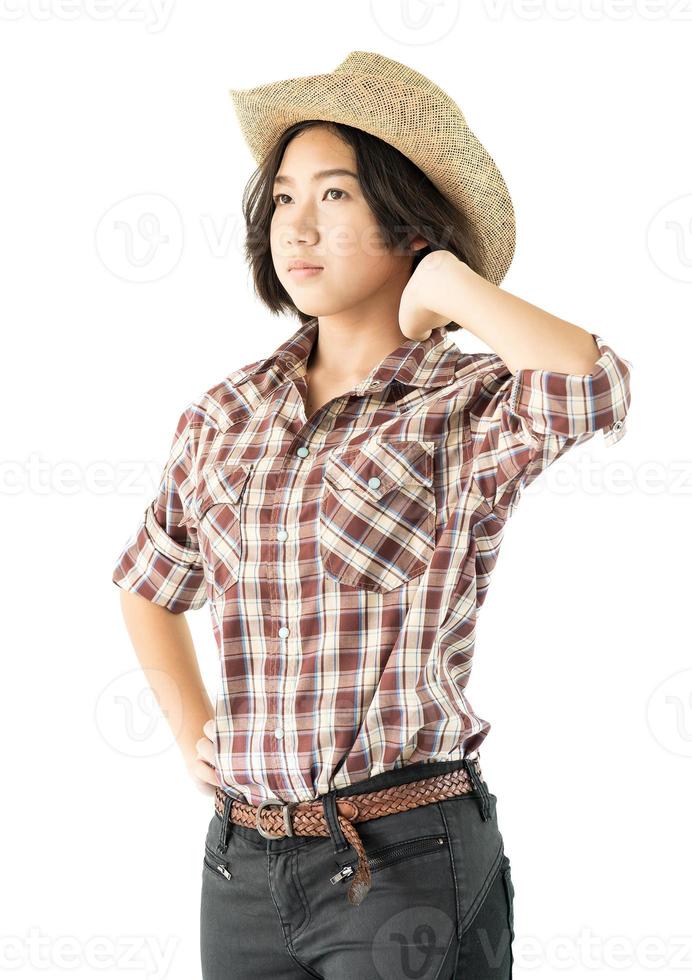 Young woman in a cowboy hat and plaid shirt with hand on her hat photo