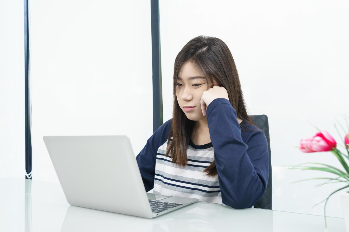 Young female student  sitting in living room and learning online photo