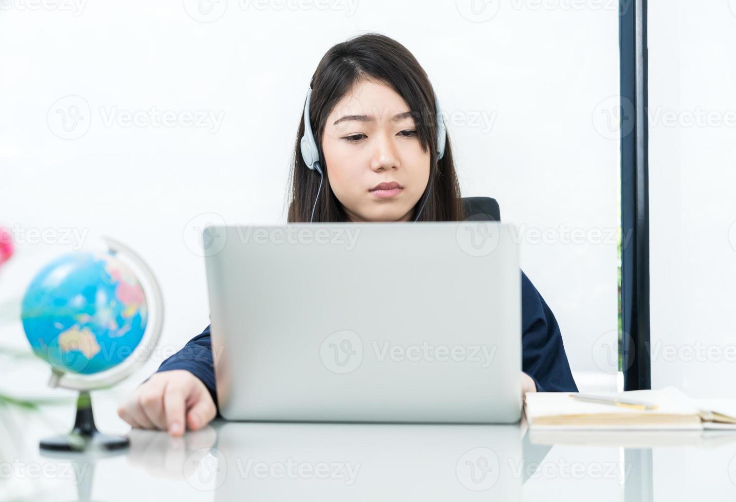 Young female sitting in living room and learning online photo