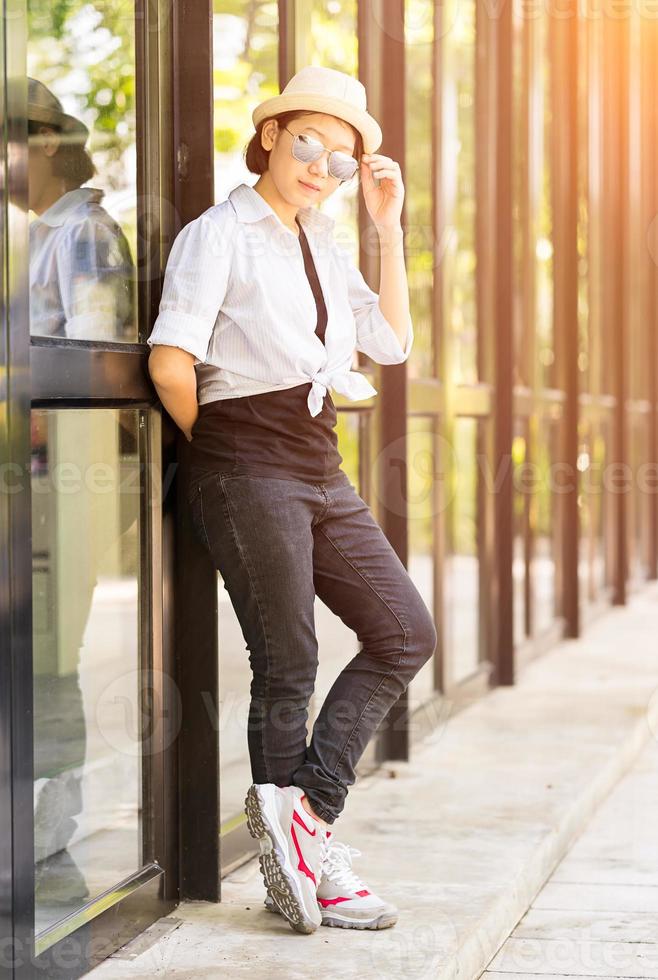 Women wearing hat standing in front of a glass building photo