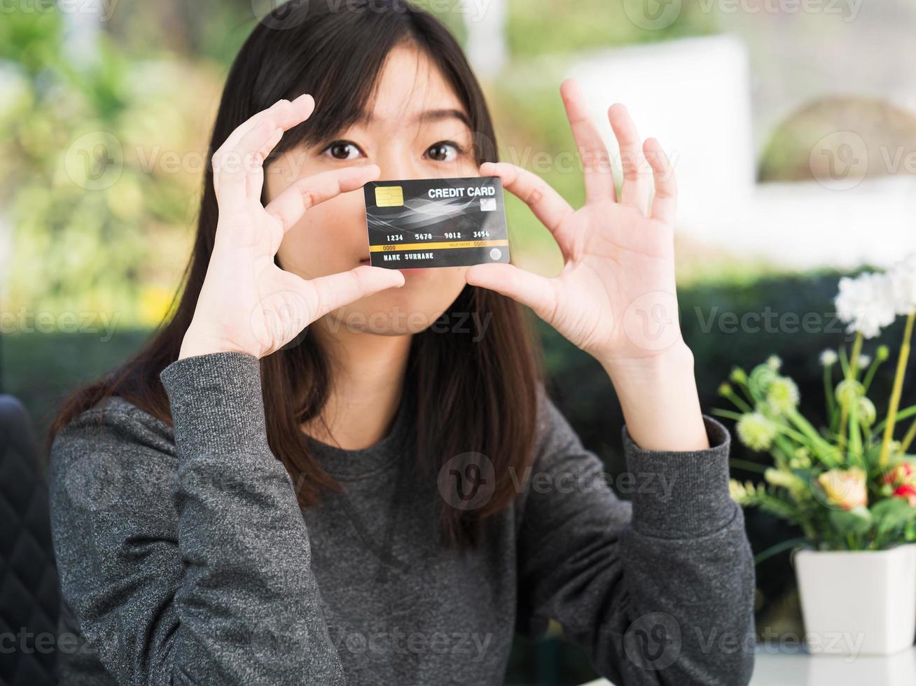 Close up young woman holding credit card photo