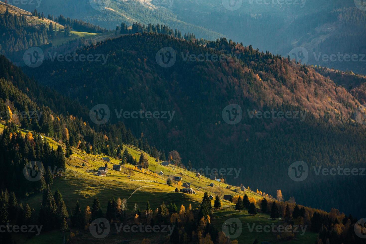 Colorful autumn landscape in the mountain village. Foggy morning in the Carpathian Mountains in Romania. Amazing nature. photo