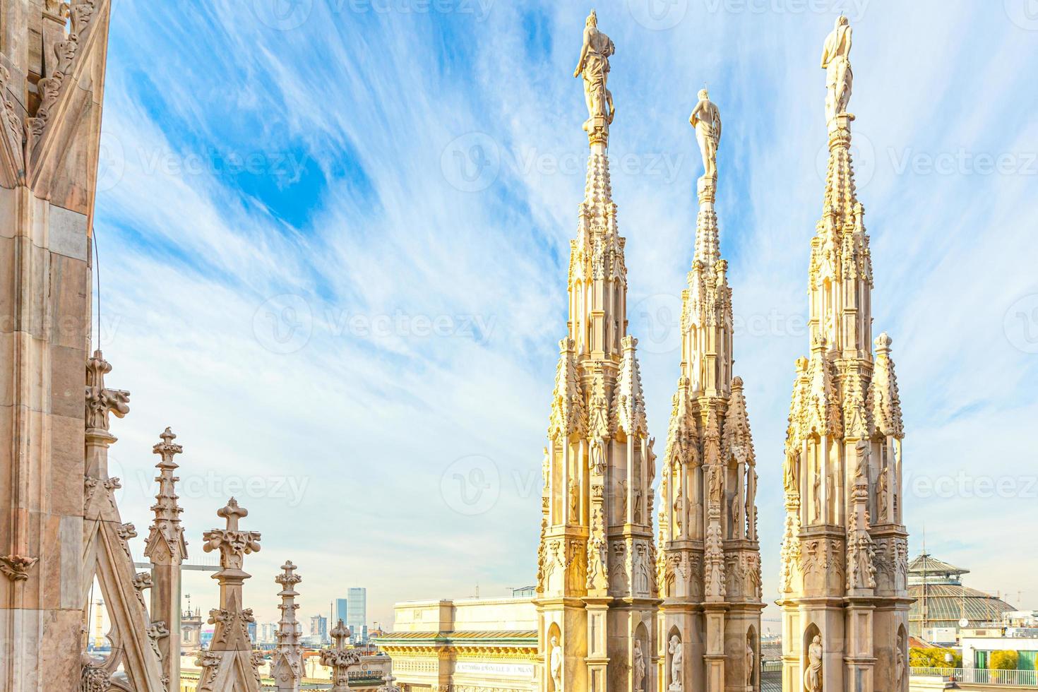Roof of Milan Cathedral Duomo di Milano with Gothic spires and white marble statues. Top tourist attraction on piazza in Milan, Lombardia, Italy. Wide angle view of old Gothic architecture and art. photo