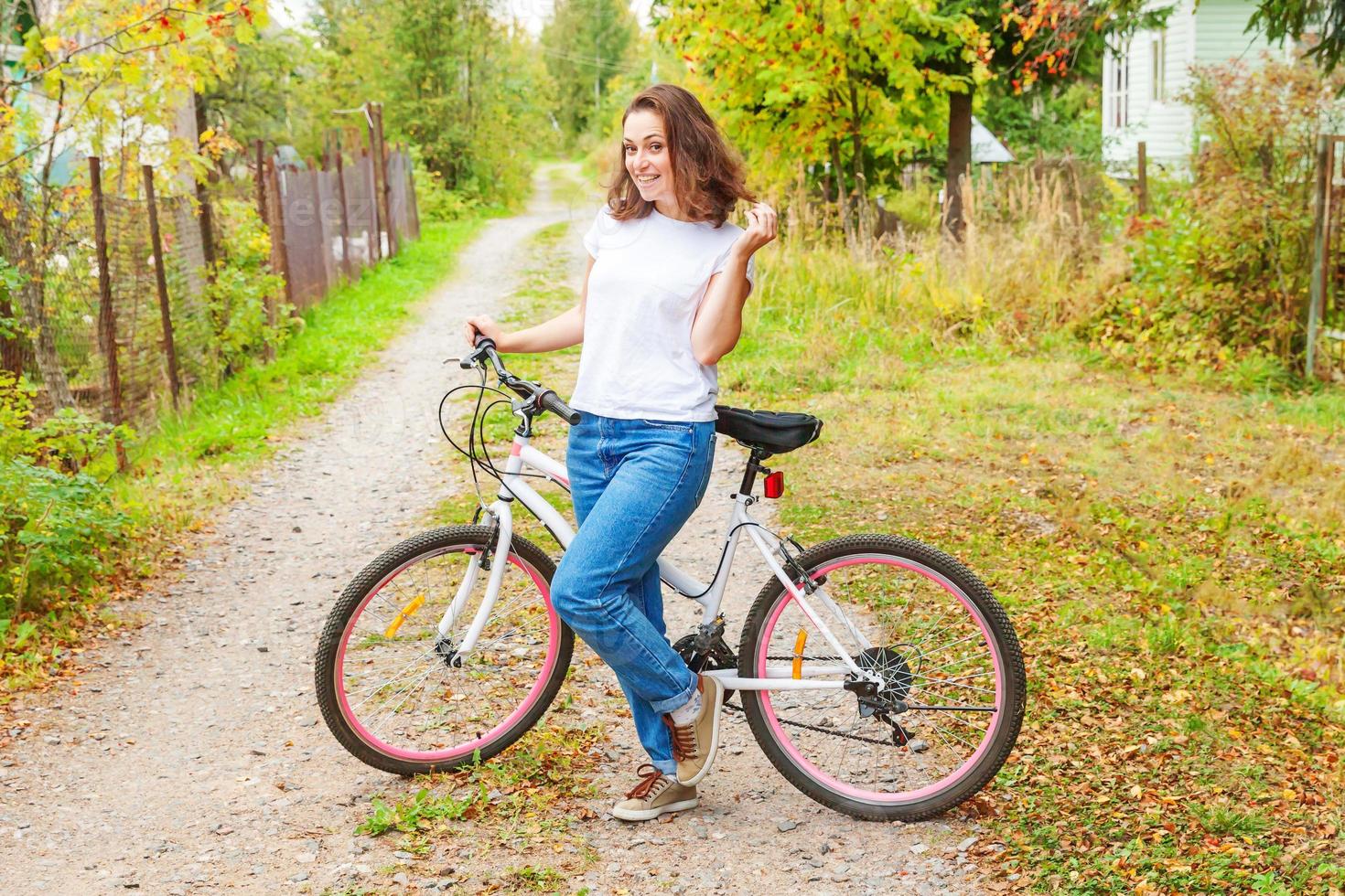 Young woman riding bicycle in summer city park outdoors. Active people. Hipster girl relax and rider bike. Cycling to work at summer day. Bicycle and ecology lifestyle concept. photo