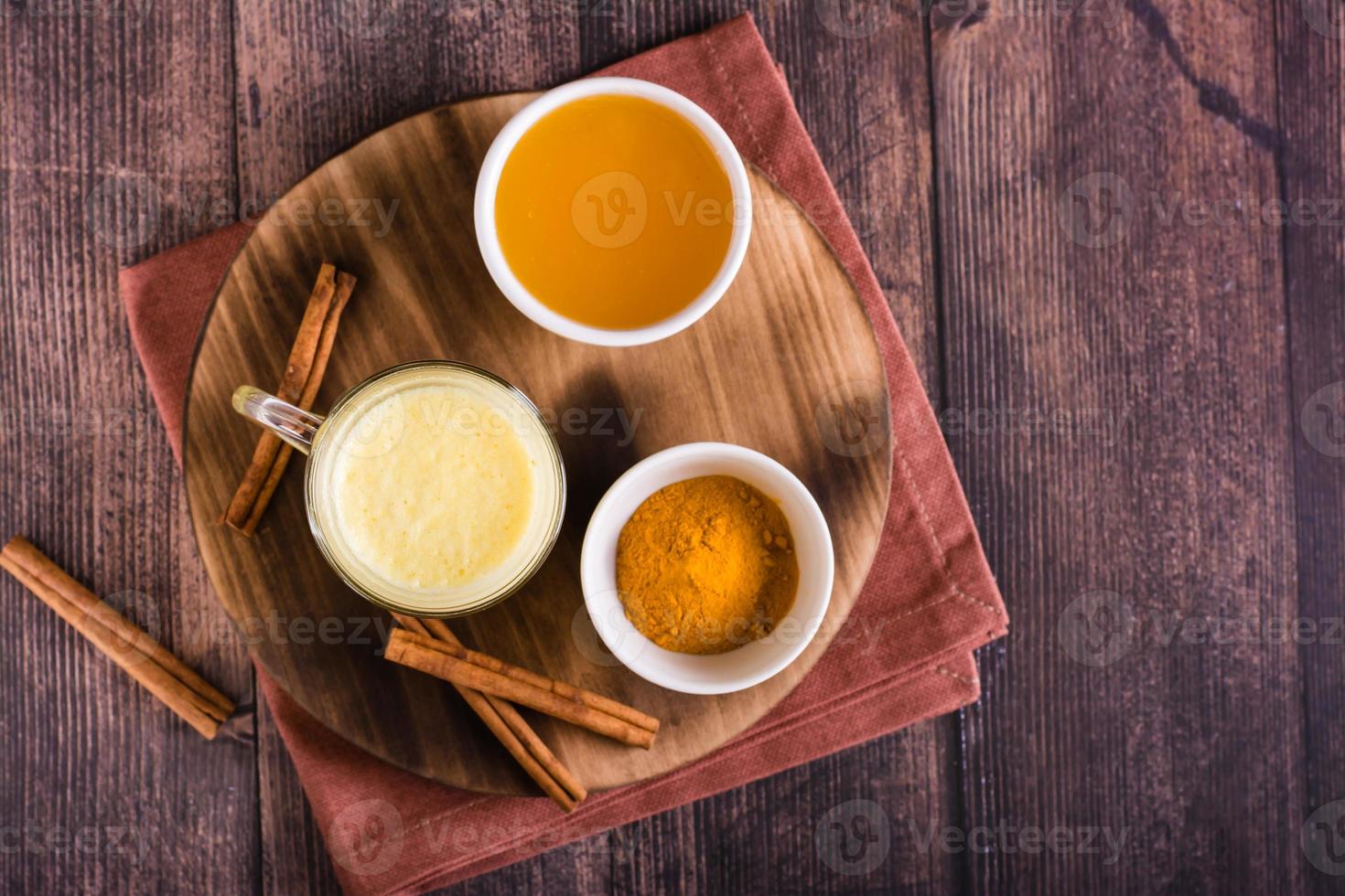 Healthy golden milk with turmeric and honey in glasses on the table. Home treatment. Top view photo