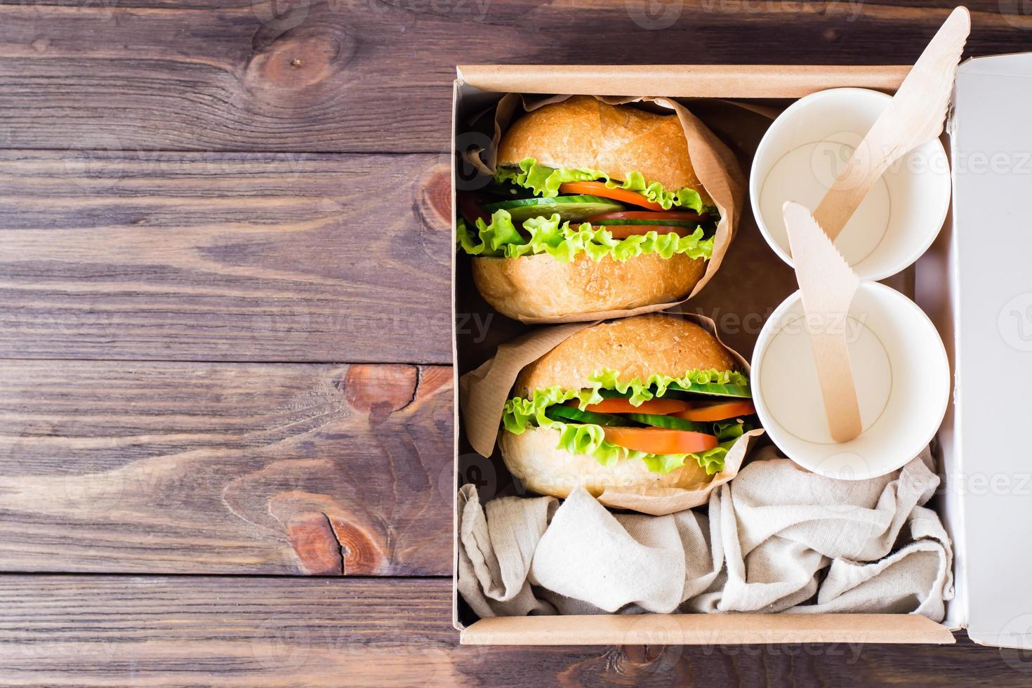 Vegetarian burgers with fresh vegetables and lettuce in a bun in a box. Fast food delivery. Top view photo