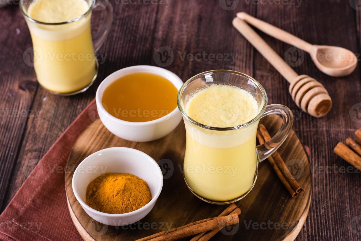 Turmeric honey golden milk in glasses on the table. Home treatment, improve immunity. photo