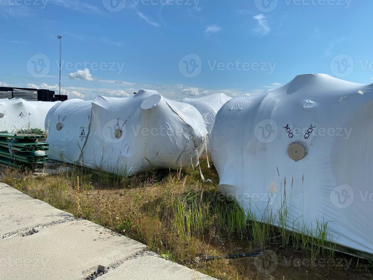 Large heat exchangers are packed in film in the warehouse of industrial equipment and materials in boxes at the storage site, temporary storage before installation photo