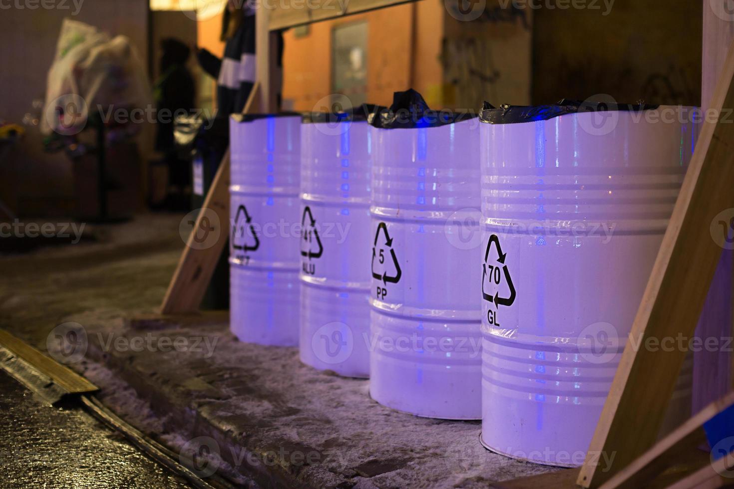 contenedores de barriles metálicos para la recogida selectiva y clasificación de basura en la calle. advertencia ambiental foto