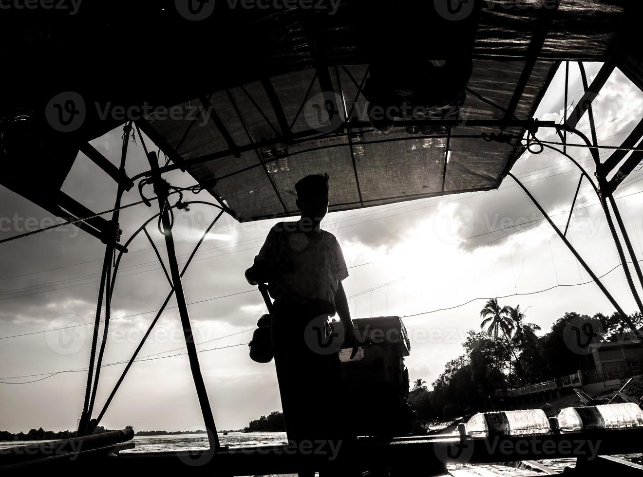 Silhouette of a passenger boat driver in the daytime backlit photo