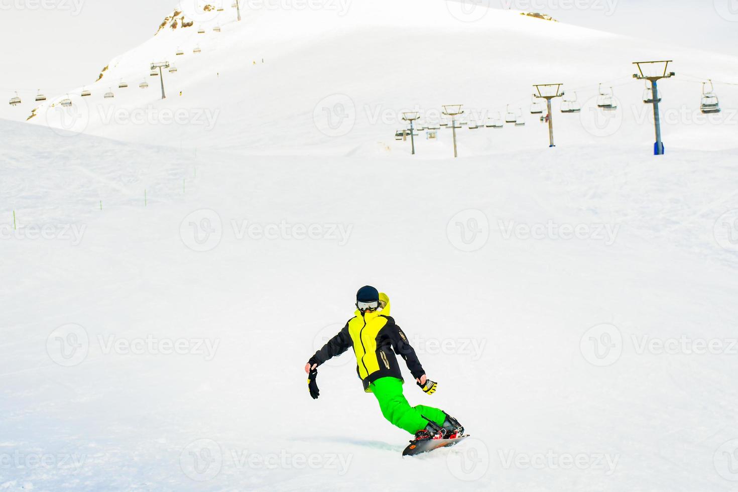 Gudauri, Georgia, 2022 - caucasian boy snowboard on slope front view stylish alone with no helmet and gloves in cold winter conditions in ski resort photo