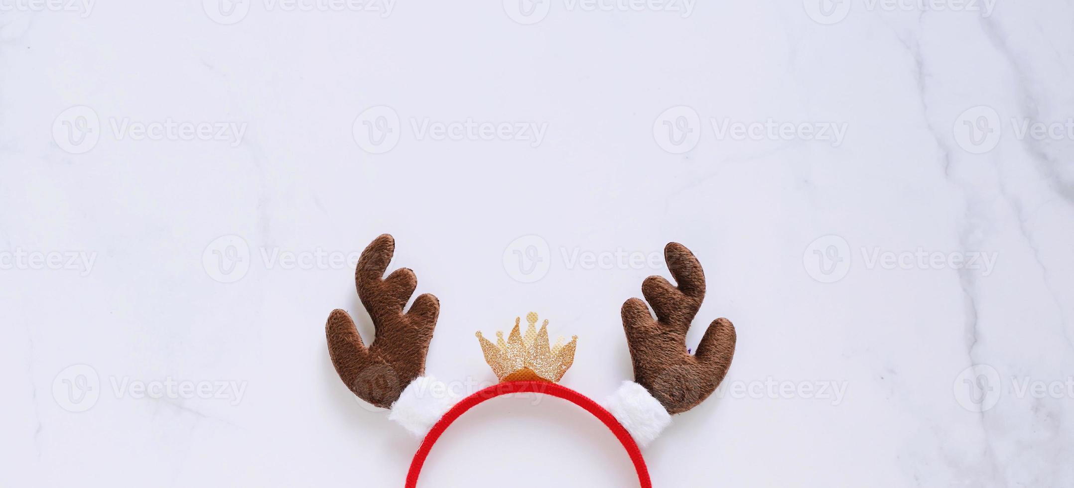 Fancy headband with reindeer antler decorative shape for christmas party and celebration on white marble background, banner style for text photo