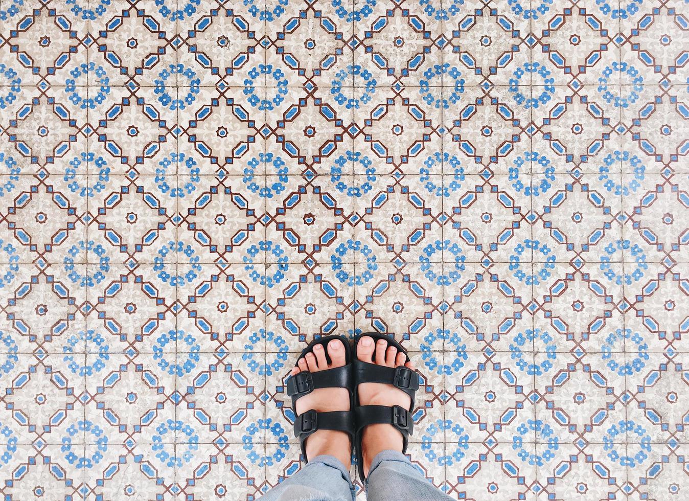 Top view of selfie feet in sandals shoes standing on seamless floor background with copy space photo