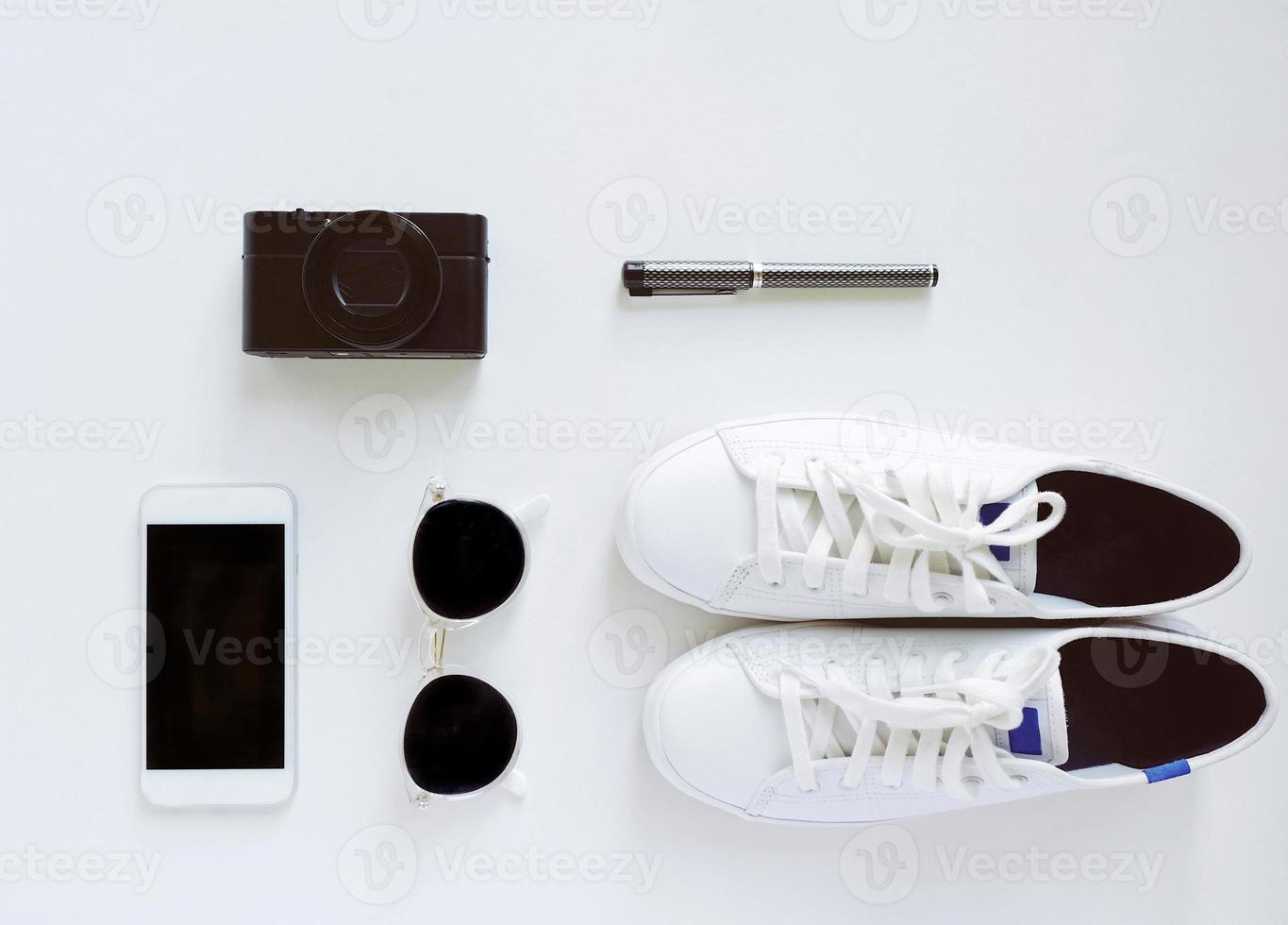 Flat lay of travel items, sneakers and accessories with smartphone on white background, fashion and lifestyle concept photo