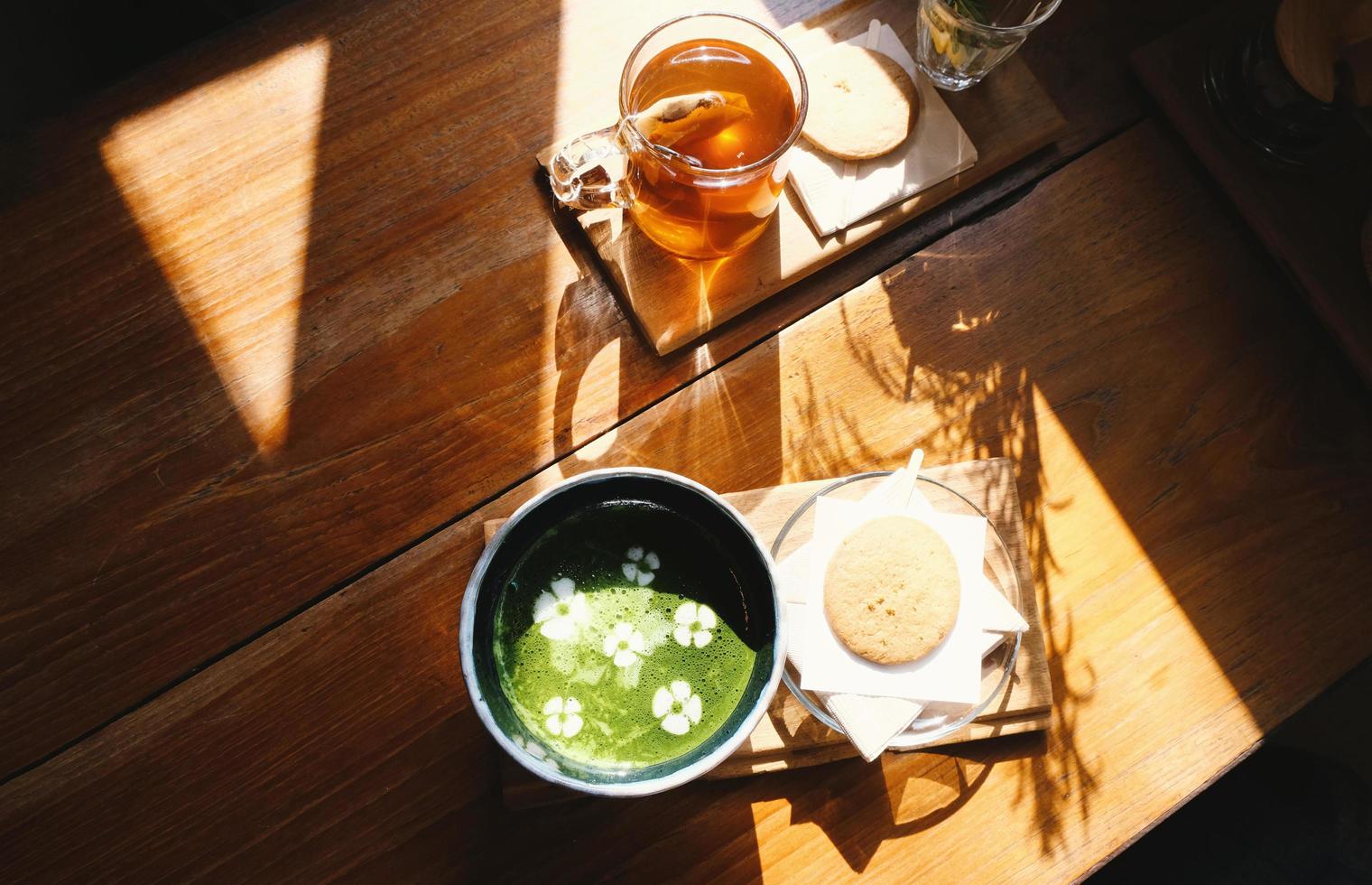 Matcha de té verde caliente de cocina casera con galleta para el descanso de la hora del té en la tarde, relajante y acogedor en casa foto