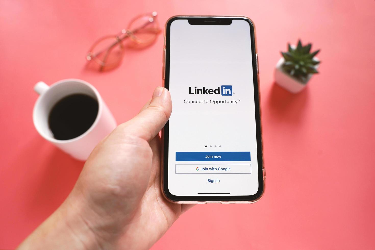 Top view of hand holding Apple iPhone XS with LinkedIn application on the screen. LinkedIn is a business-oriented social networking service. photo