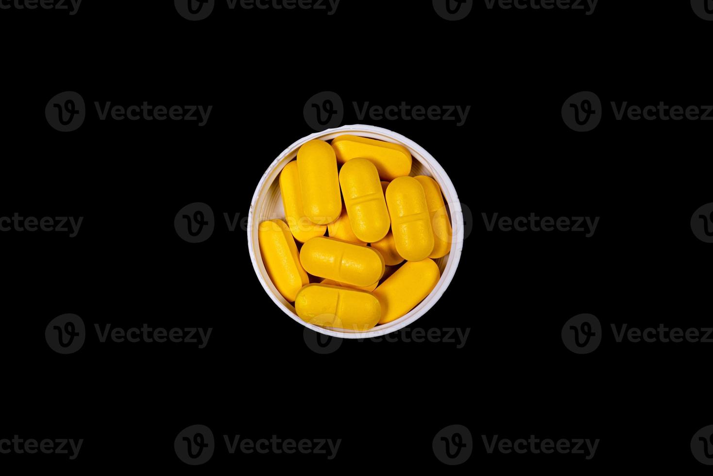 Medical orange pills on isolated on black background photo