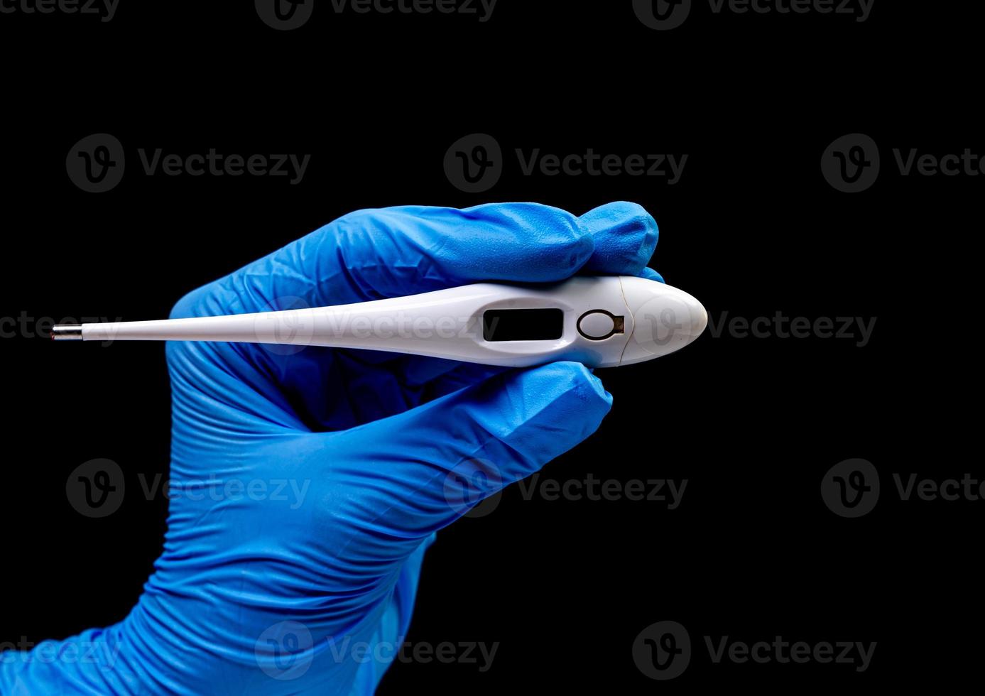Medical thermometer on isolated black background with reflection in hand photo