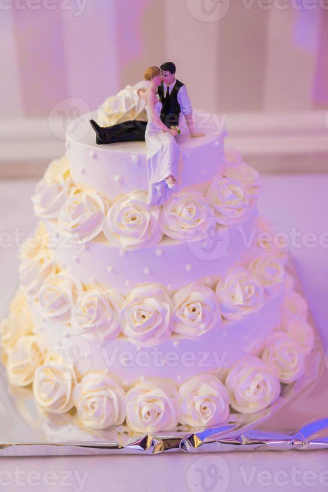 White wedding cake decorated by flowers fruits photo