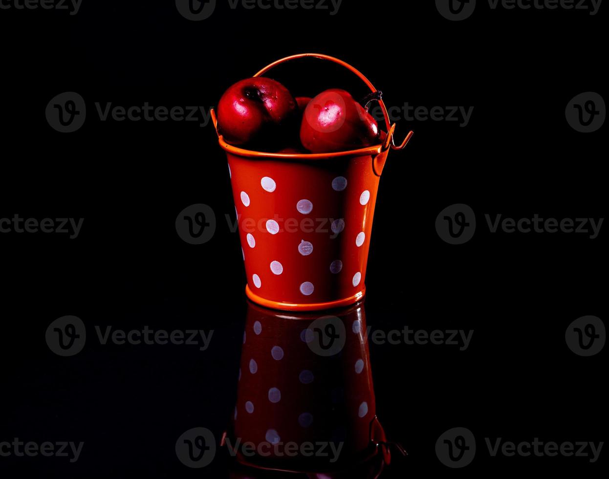 aluminum ice bucket laid in wait for use. stainless multi-colored bucket with red apples photo