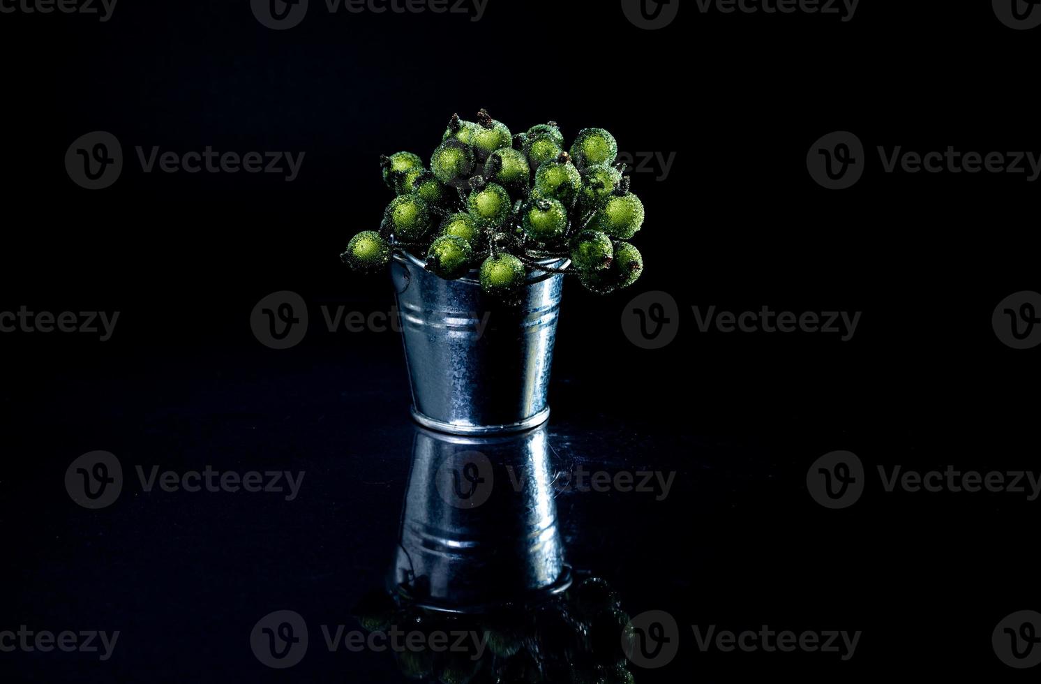 aluminum ice bucket laid in wait for use. stainless multi-colored bucket with green blue berries in ice photo