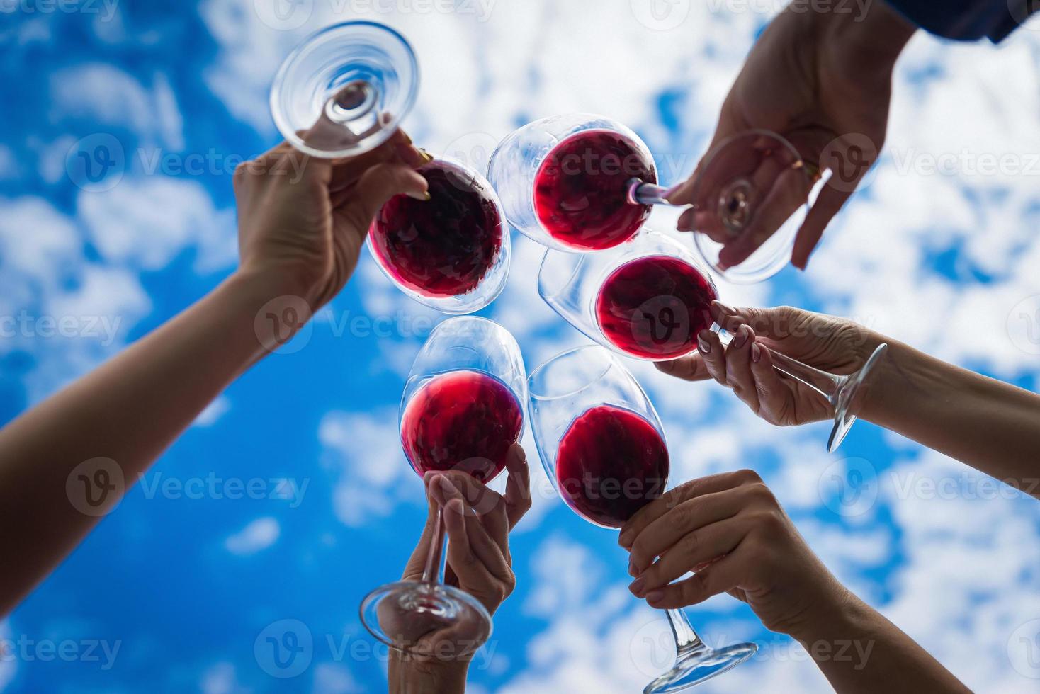 People clinking glasses with wine on the summer terrace of cafe or restaurant photo