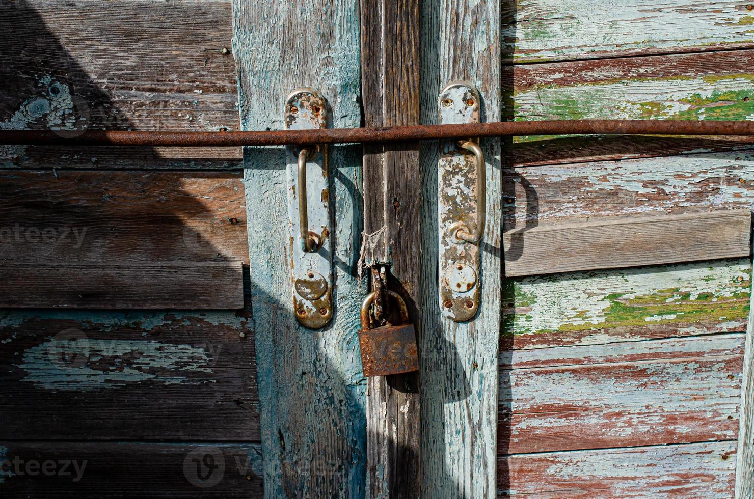 Lock on an old wooden door with rusty inserts photo