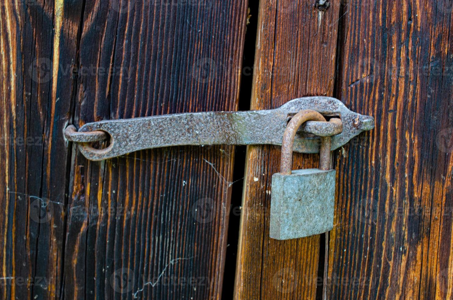 Lock on an old wooden door with rusty inserts photo