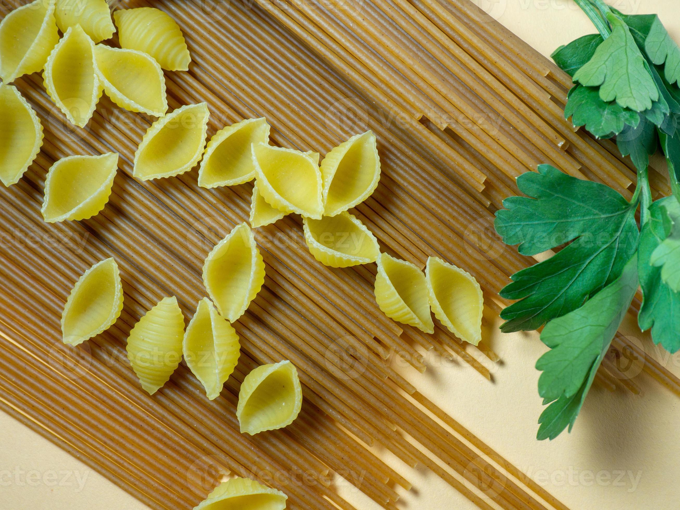 Spaghetti of two types on the table. shells and buckwheat pasta